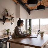 young woman surfing laptop in kitchen